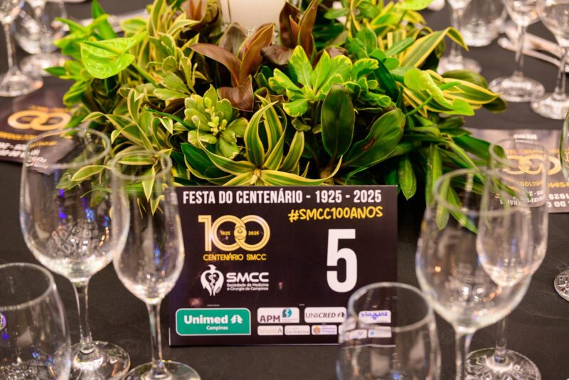 Detalhe de mesa com numeração e identidade do centenário na Festa do Centenário da SMCC