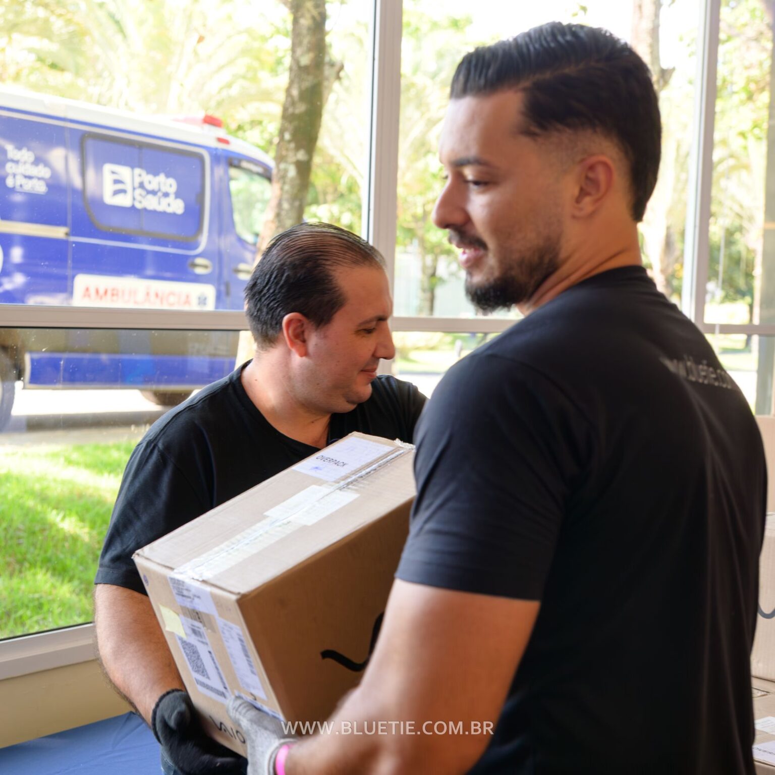 Carregadores da BlueTie com EPI transportando cases