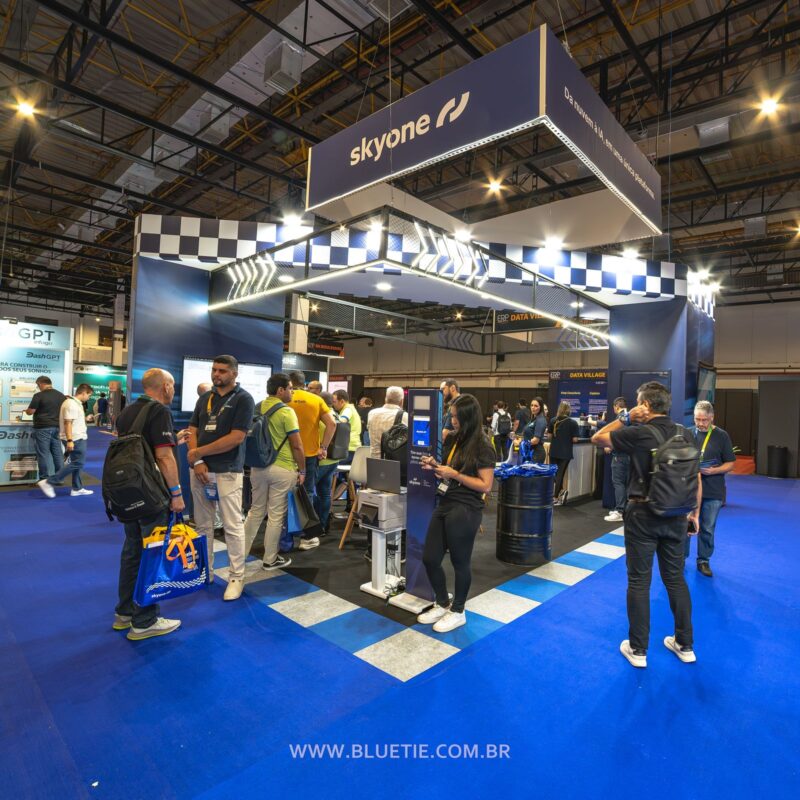 Estande de expositor (skyone) com visitantes durante o ERP Summit