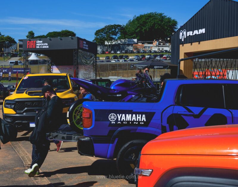 Picape RAM laranja e estande da Yamaha no festival